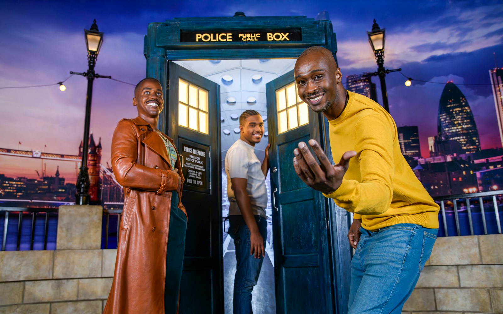 TARDIS with Doctor Who figure at Madame Tussauds, London skyline in background.