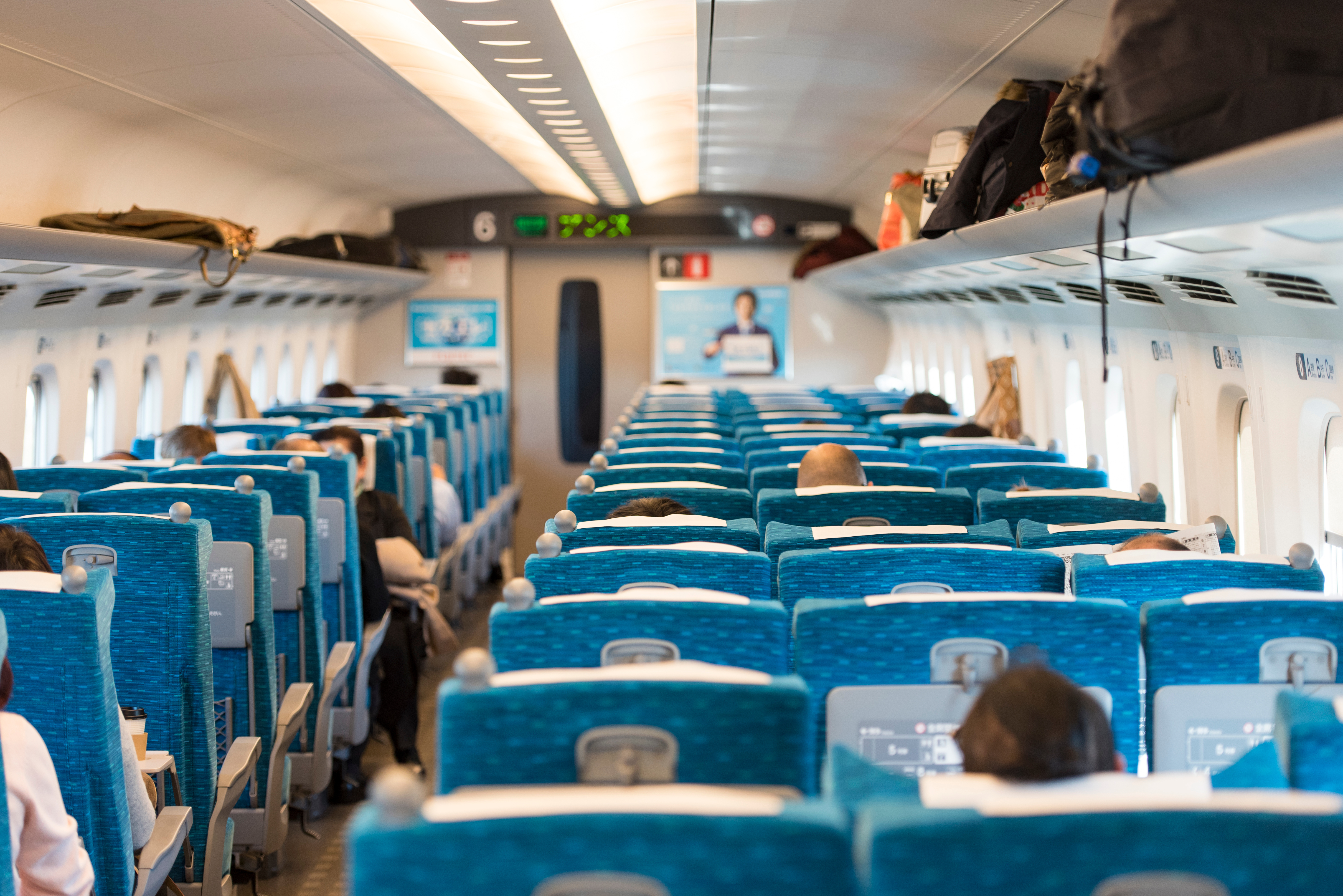 Passengers seated inside a Shinkansen train traveling from Tokyo, Japan.