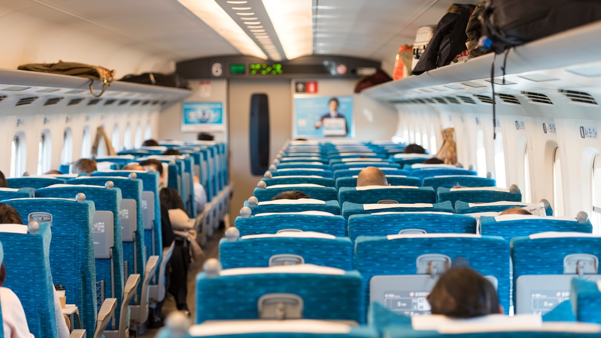 Passengers seated inside a Shinkansen train traveling from Tokyo, Japan.