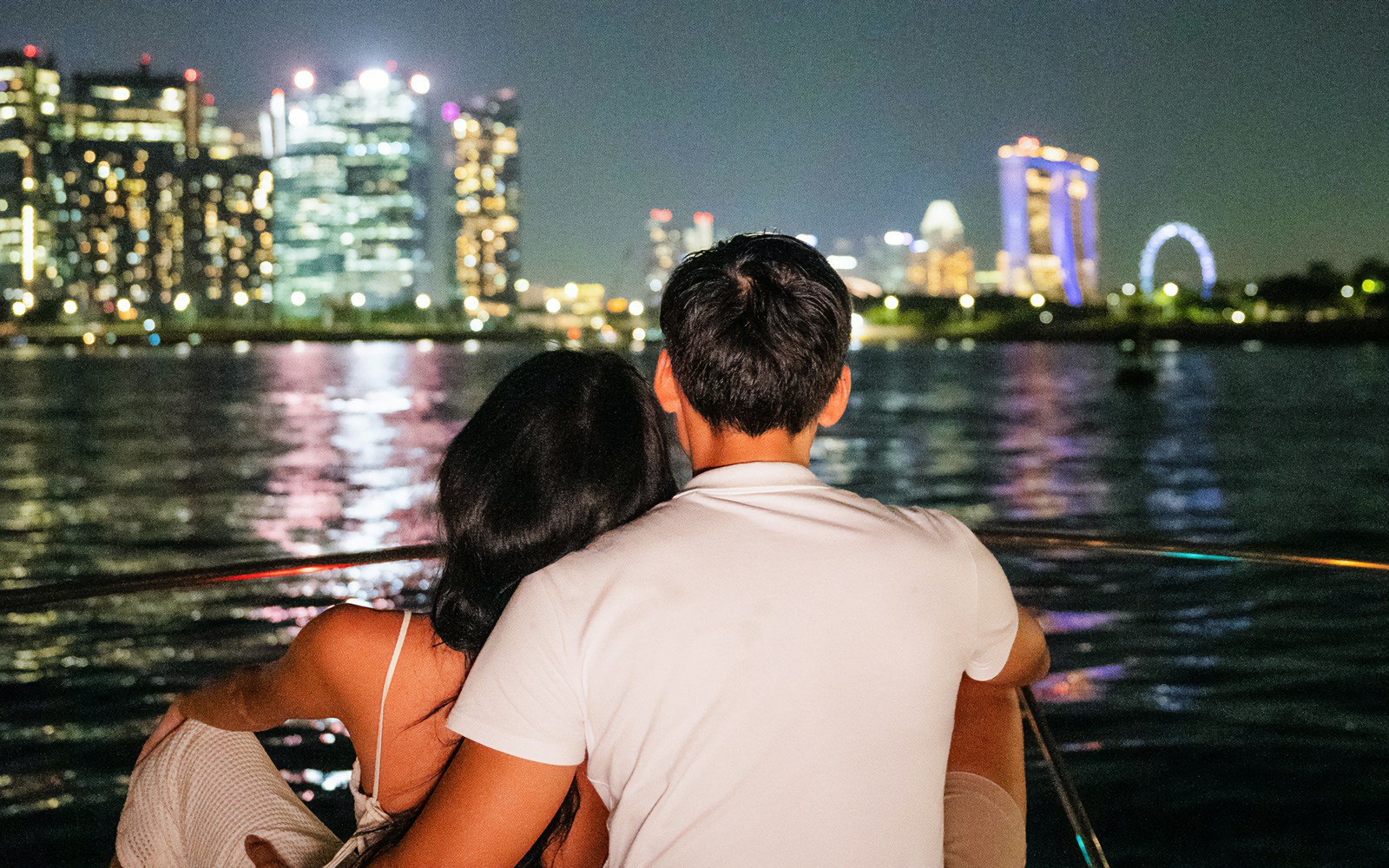 Marina Bay Sands yacht cruise with illuminated Singapore skyline at night.