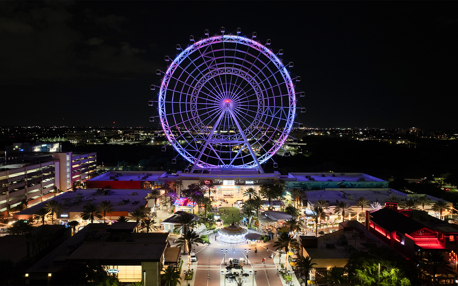 Ferris wheel illuminated at night in ICON Park, Orlando.