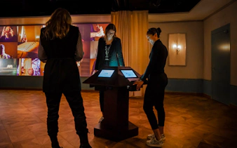 Guests interact with digital displays at Mythos Mozart Immersive Experience in Vienna.