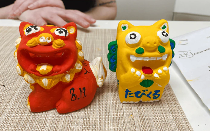 Shisa statues in red and yellow terracotta, Okinawan guardian deities.