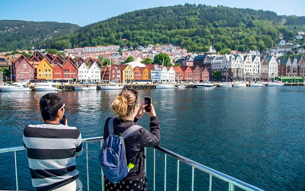 Guests on Mostraumen Fjord Cruise admiring scenic Norwegian fjord views.