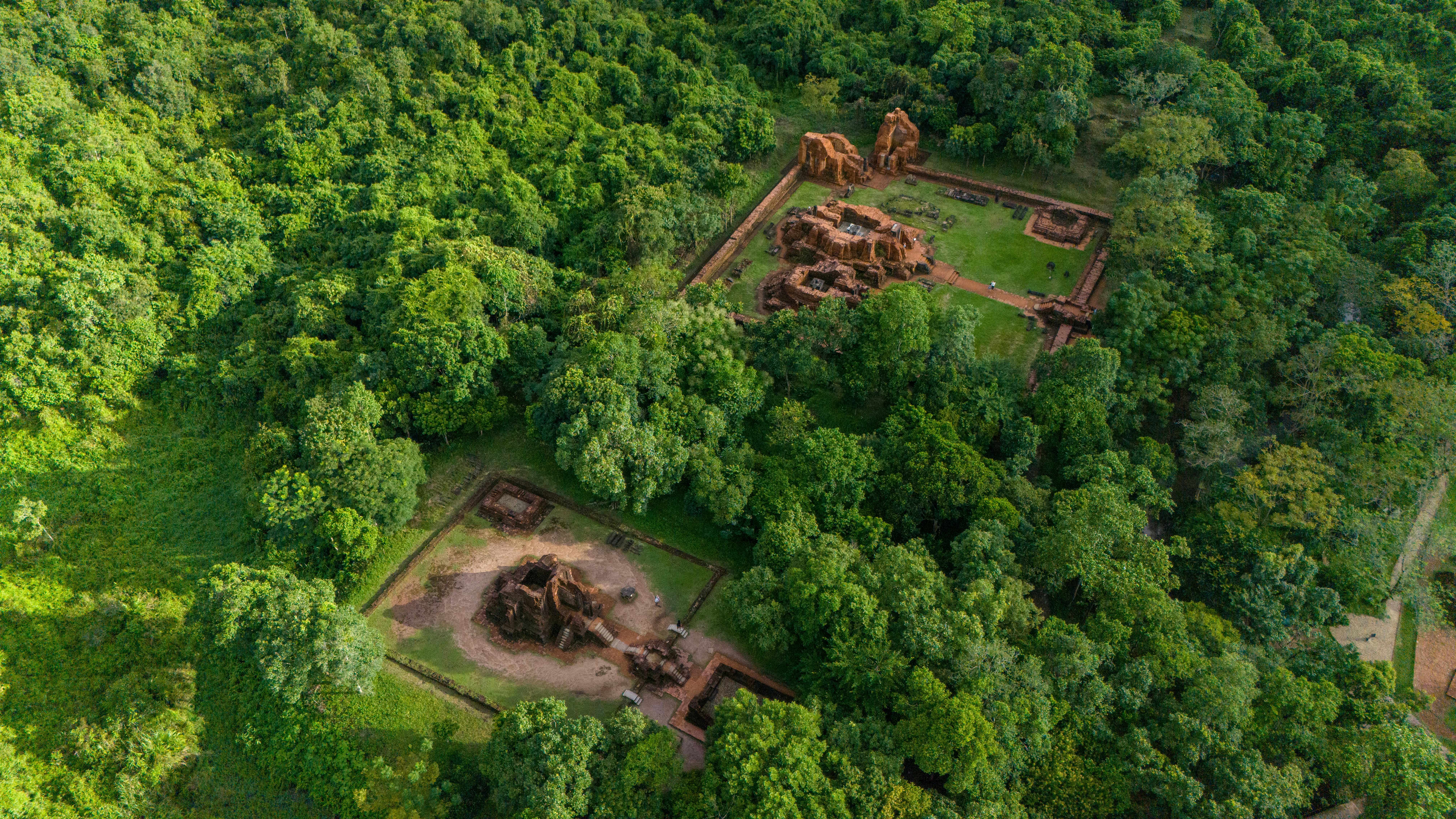 Aerial view of My Son ruins surrounded by dense green forest in Vietnam.