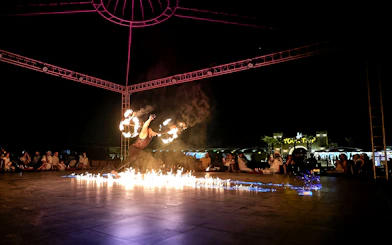 Fire performer at evening desert safari show, surrounded by audience, Dubai.