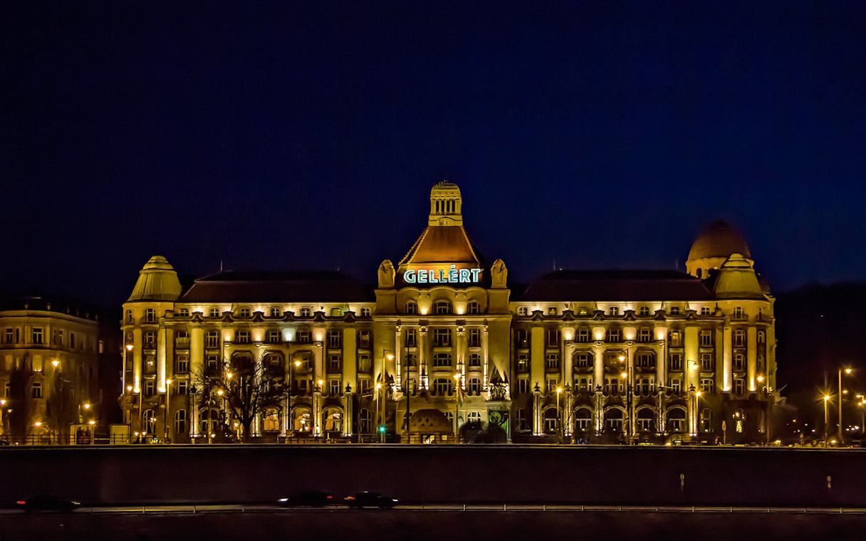 Gellert Bath illuminated at night, viewed from the Danube River in Budapest.
