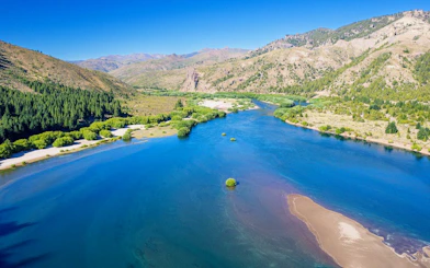 Panoramic view of a turquoise Patagonian lake with surrounding mountains and forests.