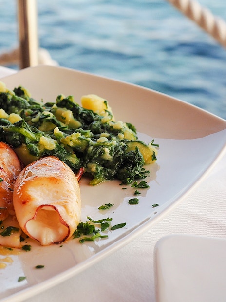 Grilled squid with greens served on a boat tour in Blue Lagoon, Duga Bay, Trogir.