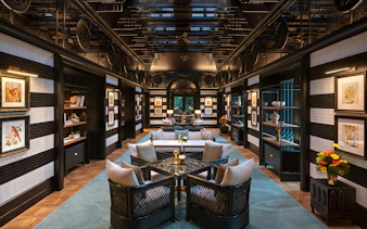 Upscale bar interior with dark wooden paneling and black marble counter at Resorts World Sentosa Singapore.