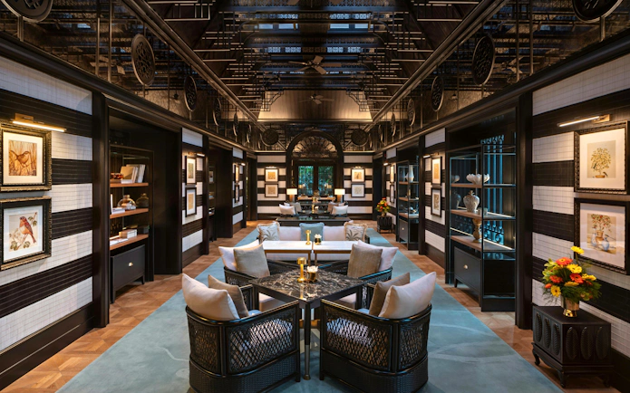 Upscale bar interior with dark wooden paneling and black marble counter at Resorts World Sentosa Singapore.