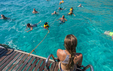Tourists swimming in clear water during Superman boat tour in Mallorca.