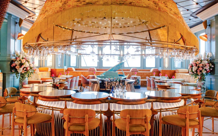 Akara Sky Hanuman rooftop bar with elegant seating and grand piano.