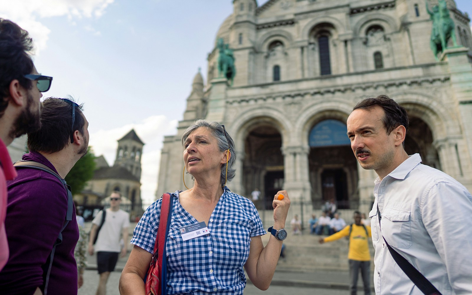 Tour guide leading a group at Sacré-Coeur Basilica, Montmartre, Paris.