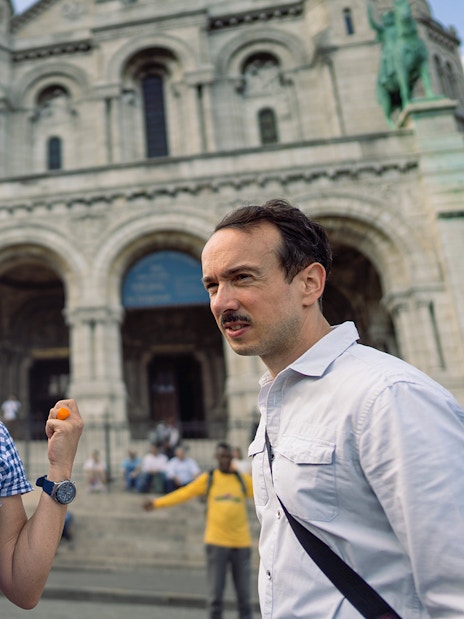 Tour guide leading a group at Sacré-Coeur Basilica, Montmartre, Paris.