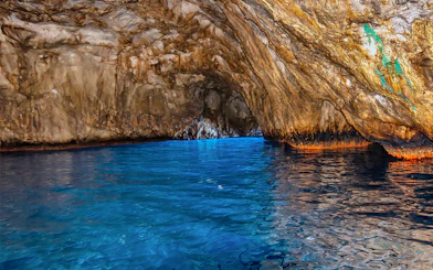 Blue waters inside Grotta Azzurra cave, Capri, with rocky walls reflecting light.