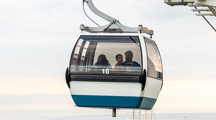 Telecabine Lisbon cable car over Tagus River with passengers.