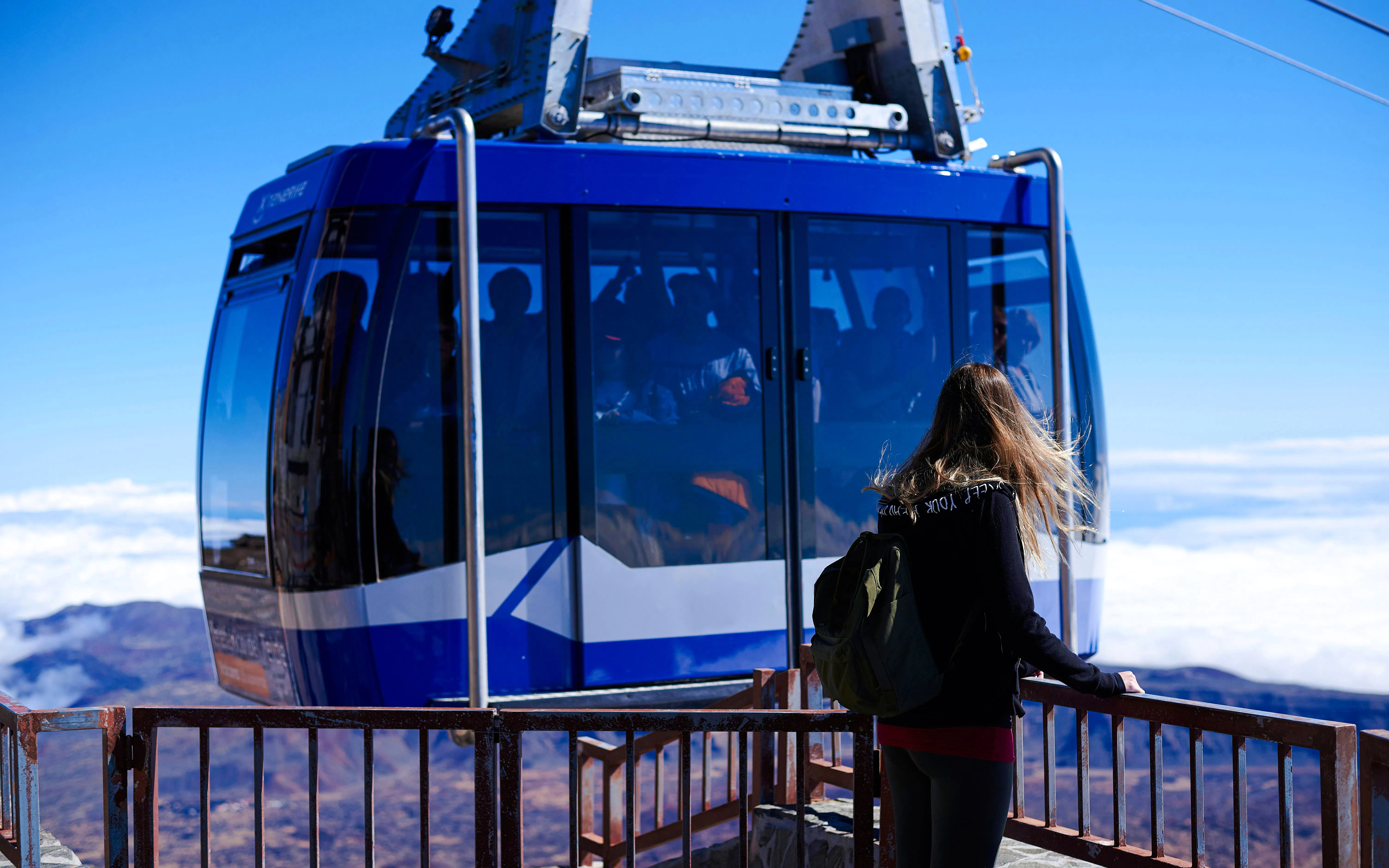 Young woman near cable car on Teide Volcano summit, Tenerife, Spain.