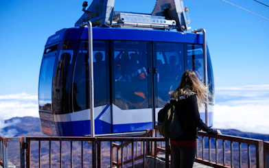 Young woman near cable car on Teide Volcano summit, Tenerife, Spain.