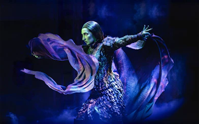 Performer in dramatic pose during Wicked musical scene.