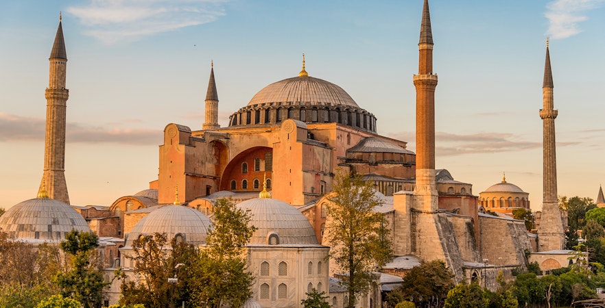 Hagia Sophia in Istanbul with minarets and domes at sunset.