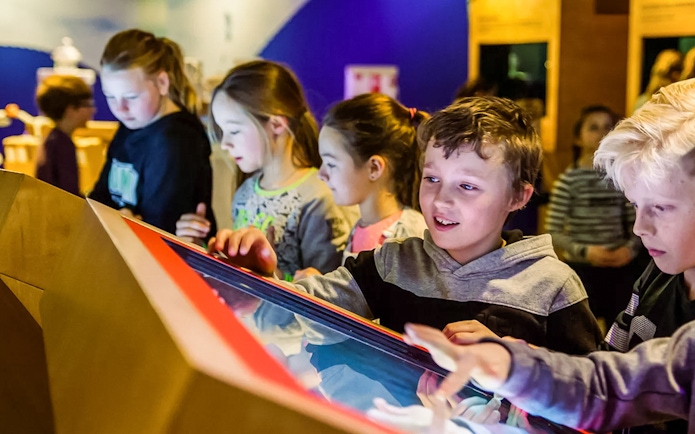 Children interacting with a display at This Is Holland 5D Ultimate Flight Experience.