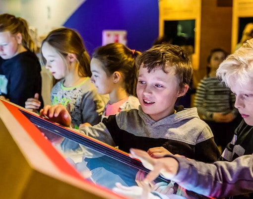 Children interacting with a display at This Is Holland 5D Ultimate Flight Experience.