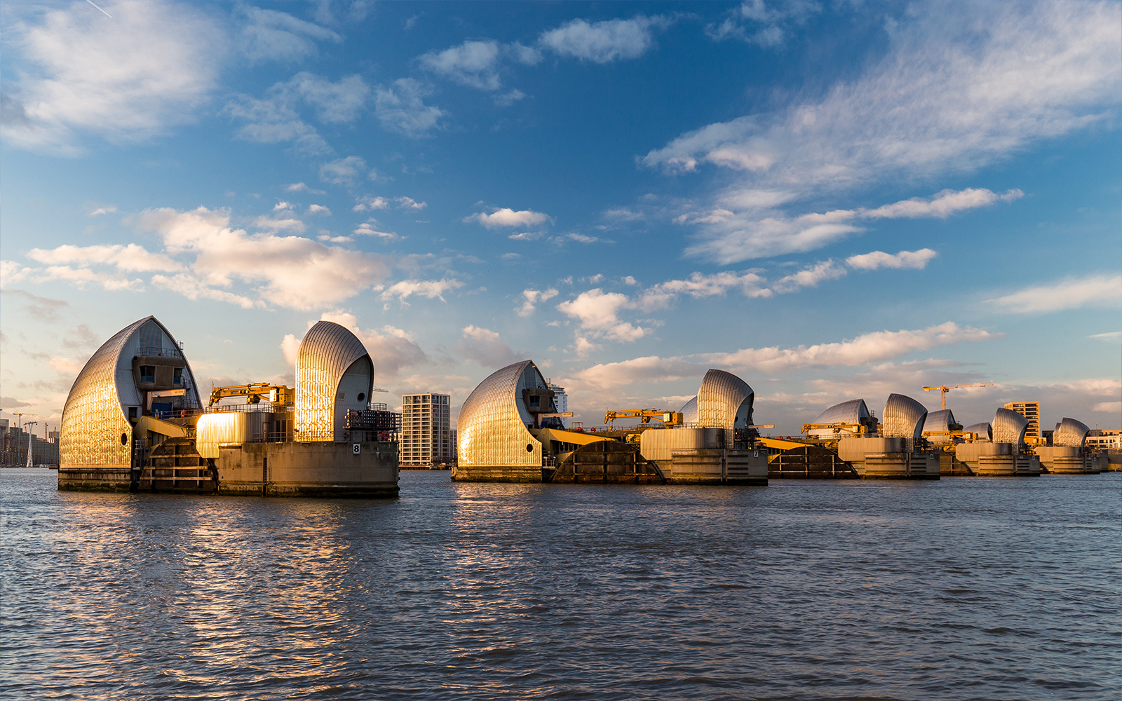 Thames Barrier structures on the River Thames in London during sunset.