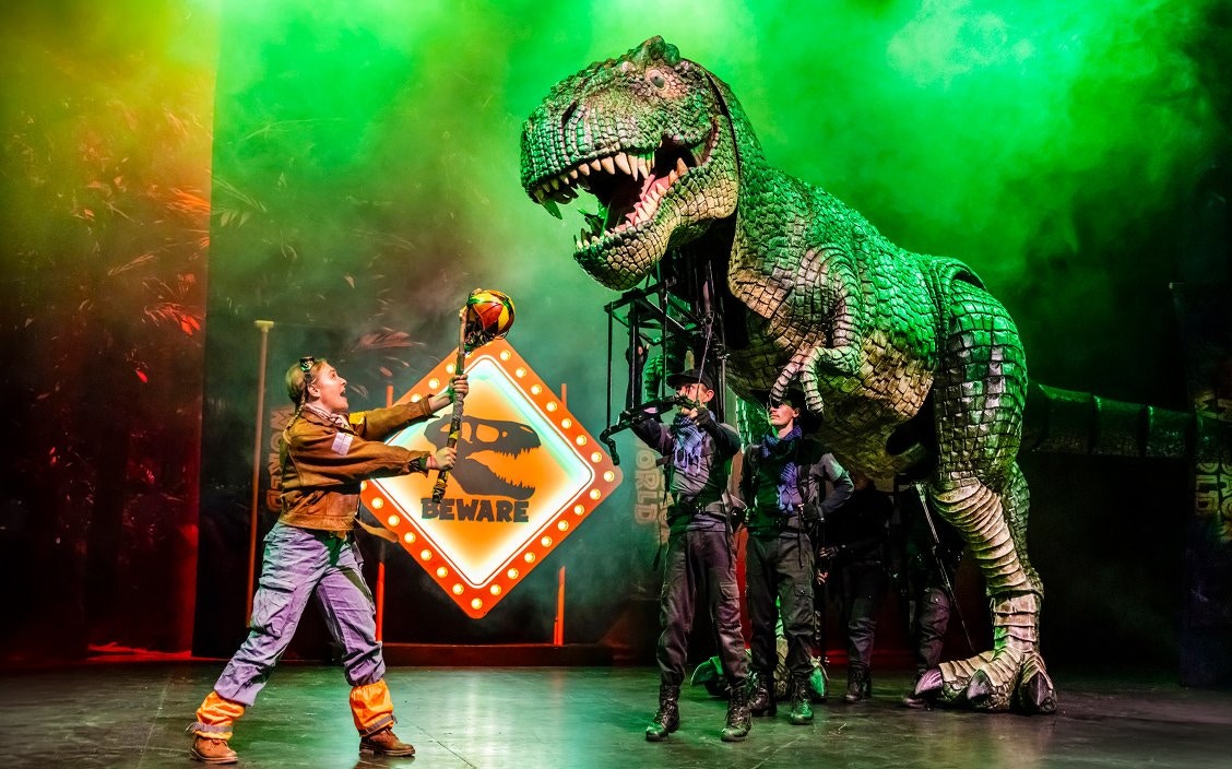 Stage performance of Dinosaur World Live with a large dinosaur puppet, Westend.