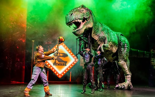 Stage performance of Dinosaur World Live with a large dinosaur puppet, Westend.