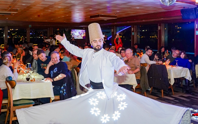 Whirling dervish performing on Bosphorus dinner cruise with live audience.