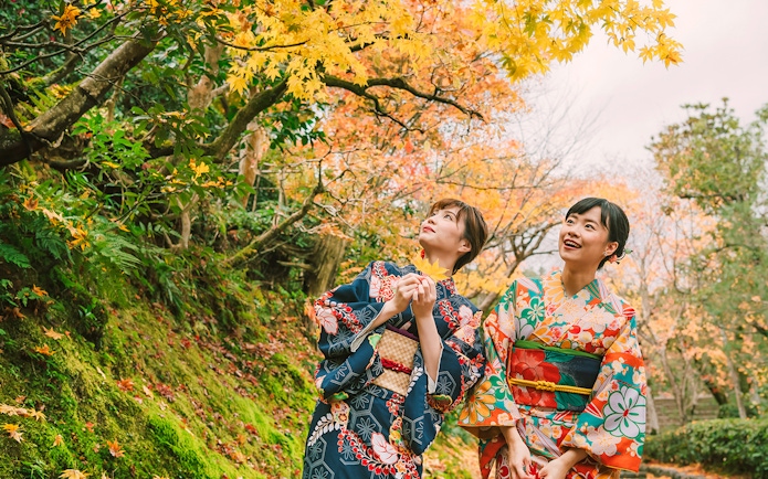 Women in kimonos enjoying autumn foliage in Gion, Kyoto.