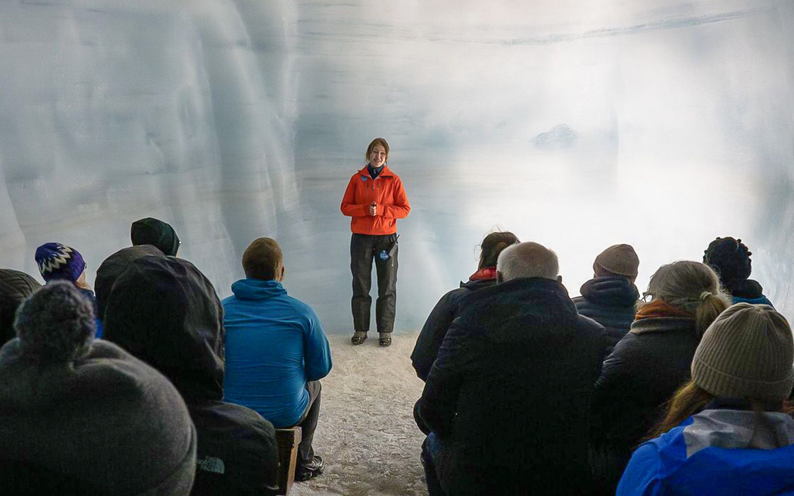 Tour guide leading guests through Langjokull ice tunnels in Iceland.