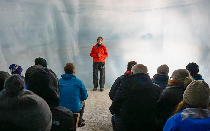 Tour guide leading guests through Langjokull ice tunnels in Iceland.