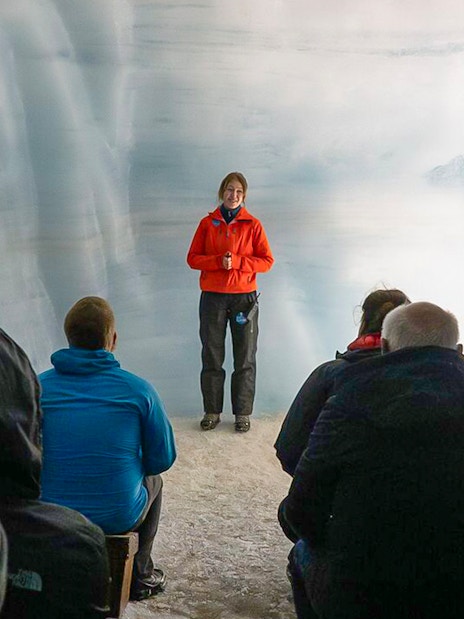 Tour guide leading guests through Langjokull ice tunnels in Iceland.