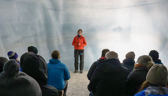 Tour guide leading guests through Langjokull ice tunnels in Iceland.