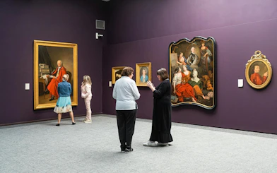 Visitors viewing paintings in Groeningemuseum gallery, Bruges.
