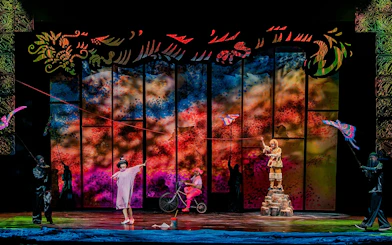 Performance of The Dragon Child with colorful backdrop and actors on stage, Sydney.