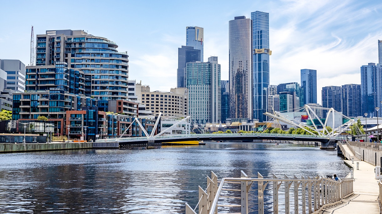 South Wharf Promenade in Melbourne with modern buildings and a bridge over the Yarra River.