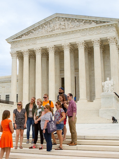 Guide discussing the Supreme Court with tourists in Washington D.C.