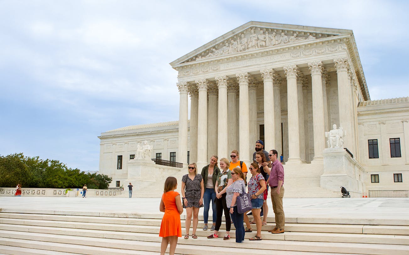 Guide discussing the Supreme Court with tourists in Washington D.C.