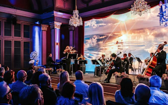 Classical concert in Vienna with musicians performing on stage, audience watching.