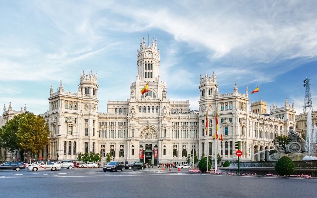 Cibeles Palace in Madrid, view from the street with cars and fountain, part of the Hop-On Hop-Off Bus Tour.
