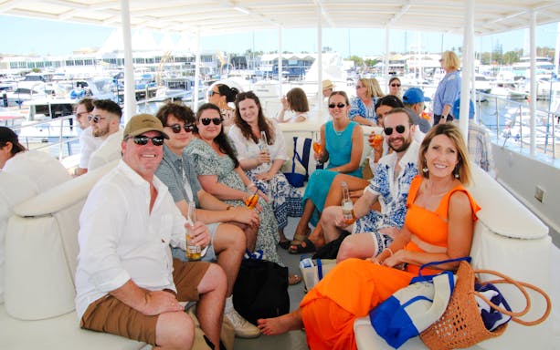 Group enjoying drinks on a luxury yacht during a Gold Coast whale watching tour.