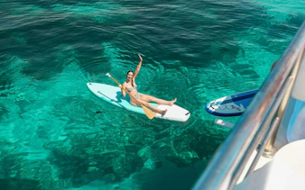 Tourist paddleboarding on clear waters during Ibiza to Formentera cruise.