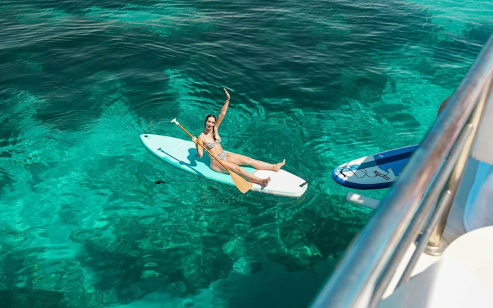 Tourist paddleboarding on clear waters during Ibiza to Formentera cruise.