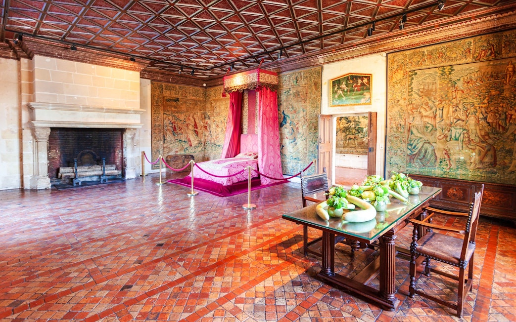 Château de Chenonceau interior with ornate tapestries and a canopy bed, Loire Valley, France.