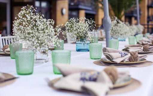Elegant table setting with green glassware and floral centerpieces at Casa 21 Underground Dining Experience.