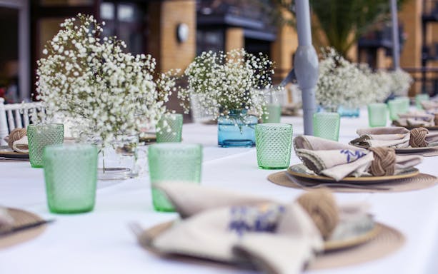 Elegant table setting with green glassware and floral centerpieces at Casa 21 Underground Dining Experience.