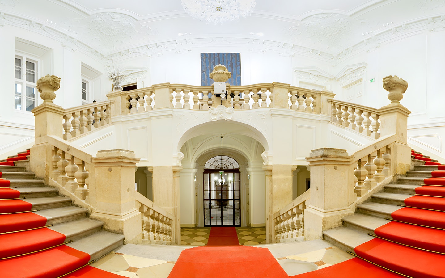 Grand staircase with red carpet at Vienna Baroque Orchestra venue.